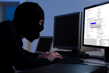 Man with ski mask at a computer