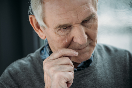 Older man with hands on cheek