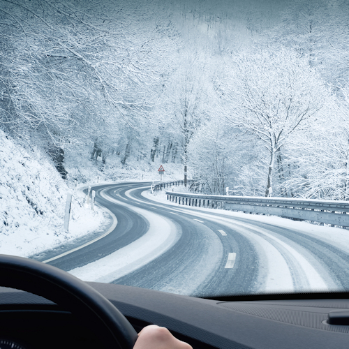 Car driving on a winding snow covered road